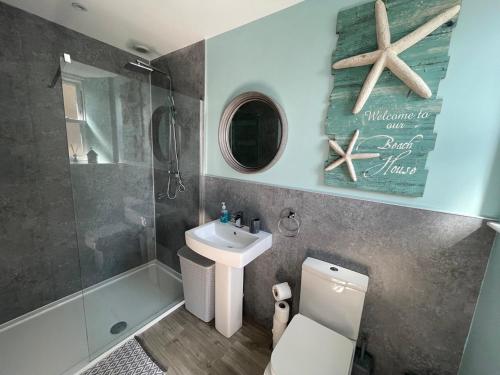 a bathroom with a sink and a shower and a toilet at The Store by Caithness Luxury Apartments NC500 - Luxury modern conversion with open plan living - Sleeps 4 in Wick