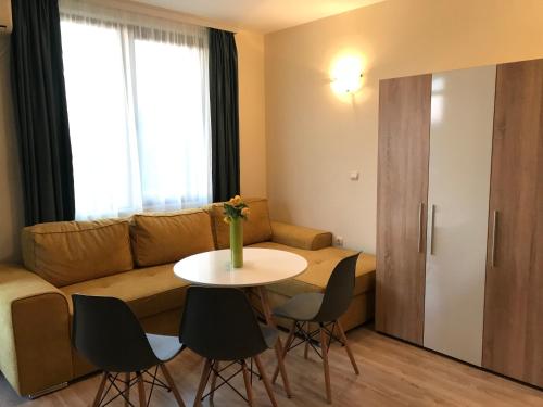 a living room with a couch and a table and chairs at Студио Приятели in Tsarevo