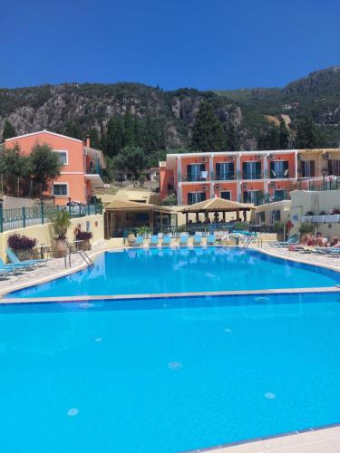 a large blue swimming pool in front of a building at Maria Studios in Paleokastritsa