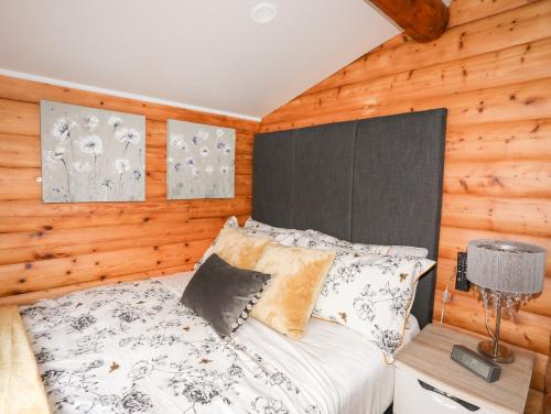 a bedroom with a bed and a wooden wall at Ty Coed - 63 in Trawsfynydd