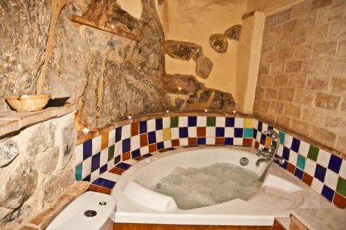 a bath tub in a bathroom with a stone wall at La Casa Mora in Jérica
