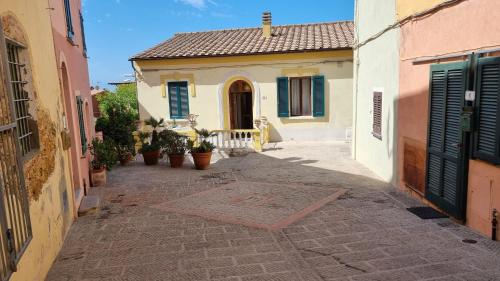 a narrow alley with a house with blue shutters at La Terrazza nel cuore di Capoliveri in Capoliveri