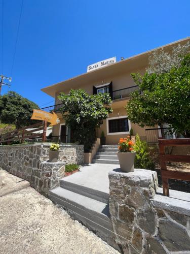 een gebouw met trappen en planten ervoor bij Santa Marina Rooms in Agia Marina Aegina