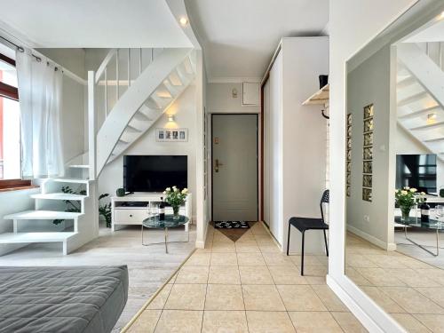 a living room with a bed and a tv at Two-story Old Town Apartment in Toruń