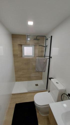 a bathroom with a toilet and a sink and a window at Lovely home, cozy corner in el Bosque, Madrid. in Villaviciosa de Odón