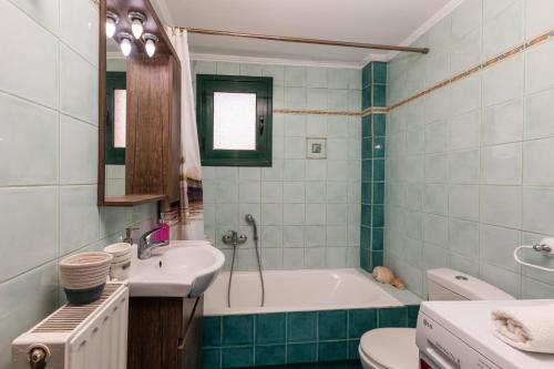 a bathroom with a tub and a sink and a toilet at A&S Seaside Maisonette in Lixouri