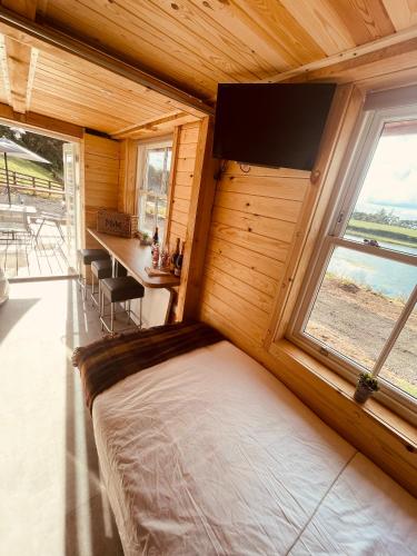 a bedroom with a bed in a room with windows at East Learmouth Lakeside Lodges in Cornhill-on-tweed