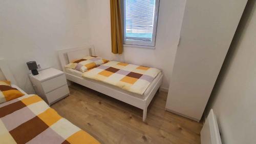 een kleine slaapkamer met twee bedden en een raam bij Apartments in Szantod - Balaton 35823 in Szántód
