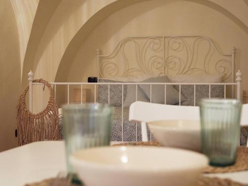 a table with glasses and a bed in a room at Blu Bari in Bari