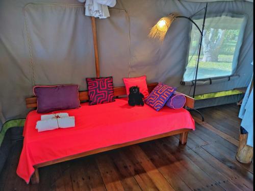 a bed in a tent with a cat sitting on it at Eden Lodge in Madirokely