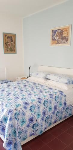 a bed with a blue and white blanket on it at SUL MARE... in Misano Adriatico