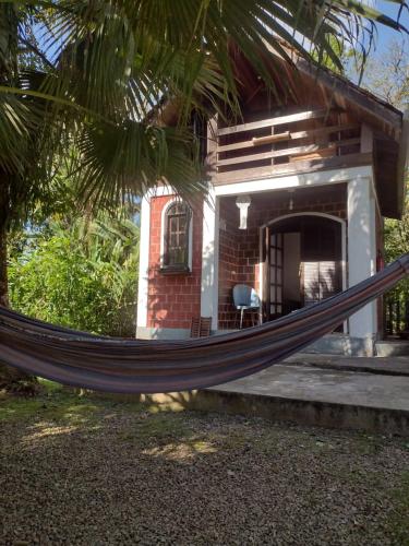 a hammock in front of a house at Pousada e Restaurante Dona Siroba in Morretes