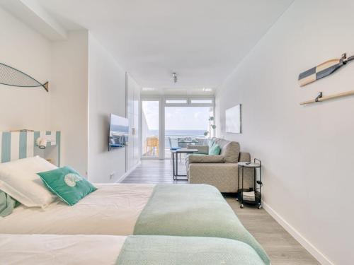 a bedroom with a bed and a chair and a balcony at Luxury Suite Over The Beach in Las Palmas de Gran Canaria