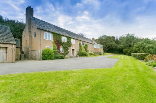 a house with a driveway and a grass yard at Cae'r Borth in Moelfre