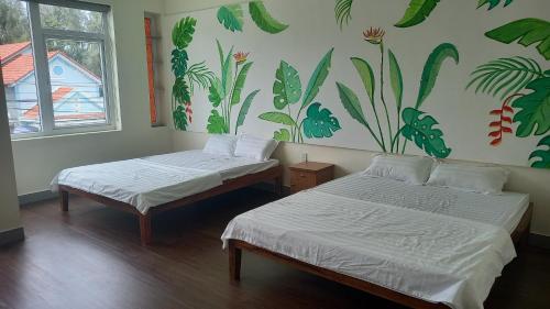 duas camas num quarto com um mural na parede em Ngoc Lan Homestay em Tam Kỳ