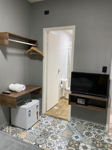 a living room with a tv and a mirror at Santa Cecília Pousada in Guarujá