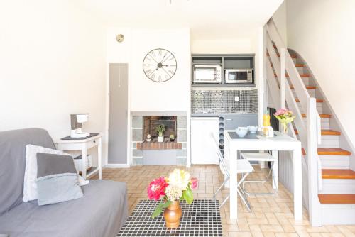 Elle comprend un petit salon avec un escalier et un bureau. dans l'établissement Le Regina Rifle - Appartement avec jardinet, à Courseulles-sur-Mer
