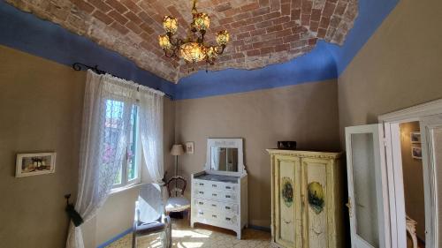 a room with a ceiling with a chandelier and a bedroom at La Terrazza nel cuore di Capoliveri in Capoliveri