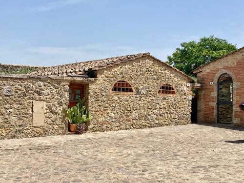 a stone building with a garage with a door at Monteriggioni Castello in Monteriggioni