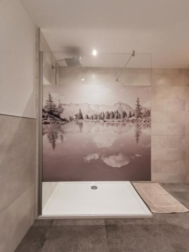 a bathroom with a shower with a painting on the wall at Apart Grafspitz in Ischgl