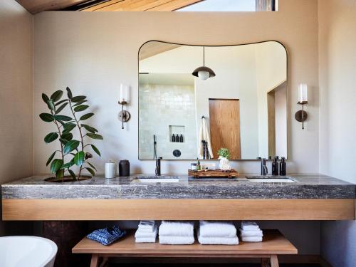 a bathroom with two sinks and a large mirror at Wildflower Farms, Auberge Collection in Gardiner