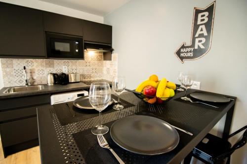 - une cuisine avec une table et des verres à vin dans l'établissement Self Checkin Automatique - Downtown - AMERICA, à La Ferté-sous-Jouarre