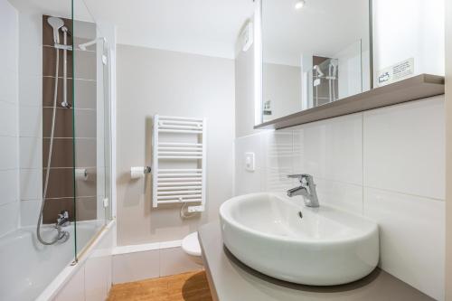 une salle de bain blanche avec un lavabo et une douche dans l'établissement Danou, à Courseulles-sur-Mer