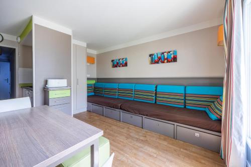 une chambre avec un long banc dans une pièce dans l'établissement Danou, à Courseulles-sur-Mer