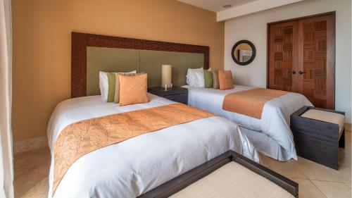 a hotel room with two beds and a mirror at Celeste Beach Residences Huatulco Curamoria Collection in Santa Cruz Huatulco