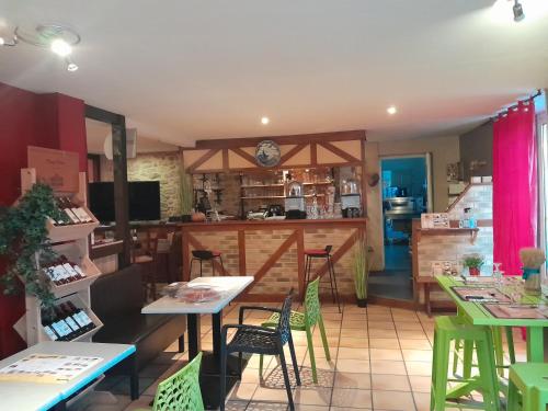 un restaurant avec des tables, des chaises et un comptoir dans l'établissement Auberge la marchadaine, à Montrollet
