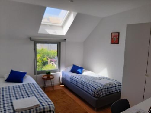 a bedroom with two beds and a window at Casa das Camélias Garden Guesthouse in Aveiro