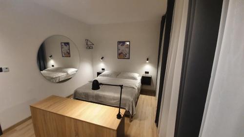 a bedroom with a bed and a mirror at Ferrata Apartamenty Zakopane in Zakopane