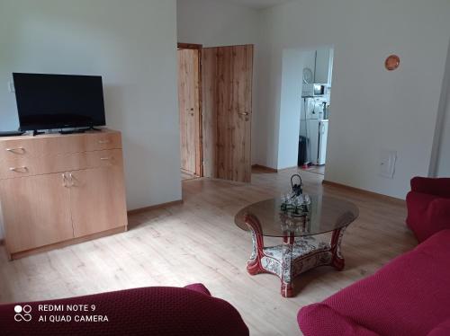 ein Wohnzimmer mit einem Tisch und einem TV in der Unterkunft Apartmány u Bečova nad Teplou in Bečov nad Teplou