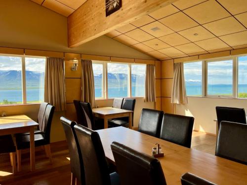 a restaurant with tables and chairs and windows at Hotel Natur Akureyri in Akureyri