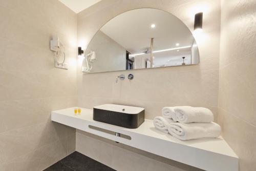 a bathroom with a sink and a mirror and towels at Mirador de Chisten in Gistaín