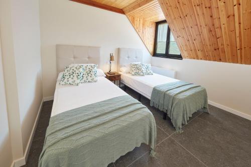 a bedroom with two beds and a window at Mirador de Chisten in Gistaín