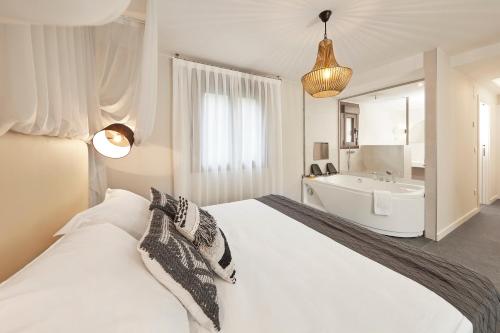 a white bedroom with a large bed and a sink at Mirador de Chisten in Gistaín