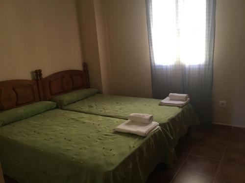 zwei Einzelbetten in einem Zimmer mit Handtüchern darauf in der Unterkunft PRECIOSO APARTAMENTO EN PRIMERA LÍNEA DE PLAYA in Isla Canela