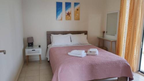 a bedroom with a bed with two towels on it at Kalliope Apartments in Tsoukalades