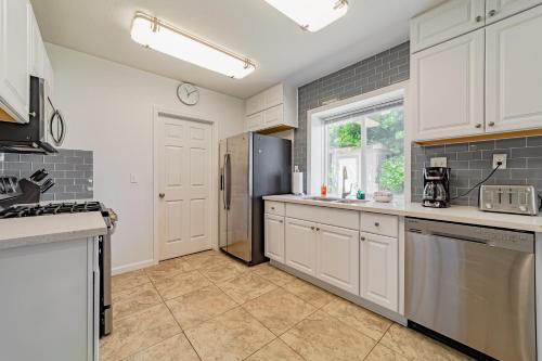 a kitchen with white cabinets and a black refrigerator at Balboa Rendezvous in McKinleyville