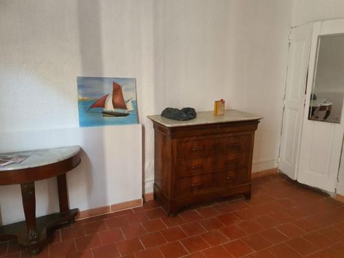 une chambre avec une table et une peinture d'un bateau sur le mur dans l'établissement Liberté17/2, à Arles