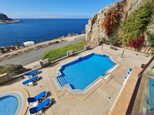 a swimming pool with chairs and a view of the ocean at Four Seasons - Playa del Cura in Playa del Cura