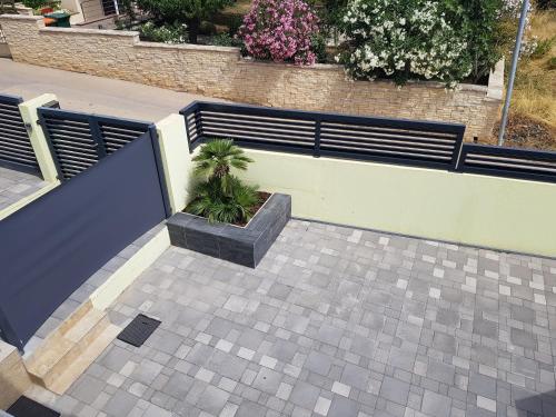 a patio with a bench and a plant at Yellow Cube Holiday Apartments in Kožino