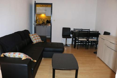 sala de estar con sofá negro y mesa en Marco Polo en Horbourg