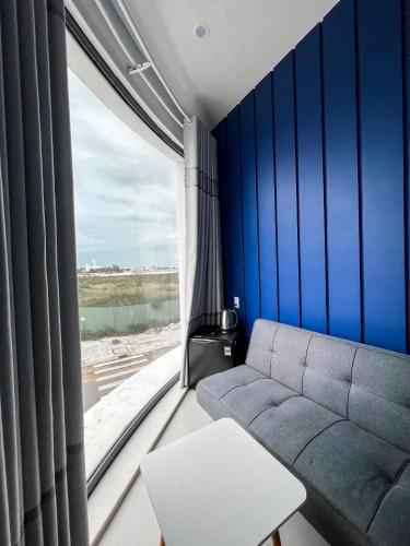 a living room with a couch and a large window at New Hotel in Rach Gia