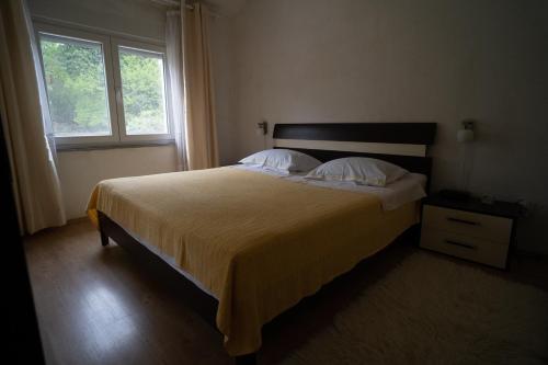 um quarto com uma cama grande e uma janela em Holiday Home Slap Koćuša em Ljubuški