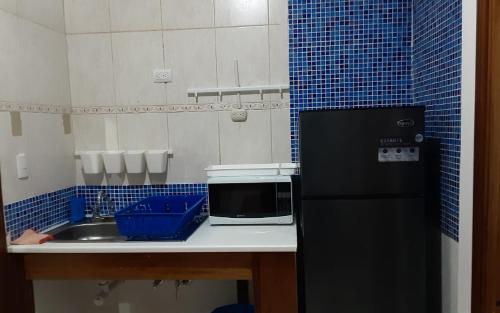 een keuken met een zwarte koelkast en een wastafel bij Villa Colonial suite n2 presidencial in Río San Juan
