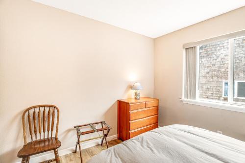 a bedroom with a bed and a chair and a window at Sunrise Serenity in Manzanita