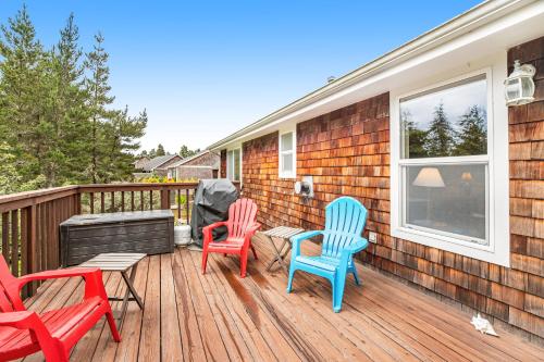 three chairs and a table on a deck at Sunrise Serenity in Manzanita