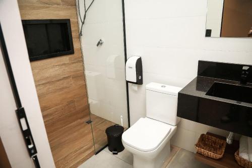 a small bathroom with a toilet and a sink at Globo Lar Studios in Limeira
